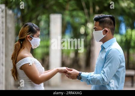 201215 -- MAKATI, 15 décembre 2020 -- Un couple portant des masques faciaux est vu lors d'un mariage masqué dans un parc de Makati City, aux Philippines, le 15 décembre 2020. Le gouvernement philippin a imposé une politique plus stricte en matière de couverture du visage en raison des préoccupations d'une augmentation possible des cas pendant la période des fêtes. PHILIPPINES-MAKATI-MASQUÉ MARIAGE RouellexUmali PUBLICATIONxNOTxINxCHN Banque D'Images