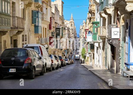 La Valette, Malte - 3 août 2023 : voitures garées dans l'une des rues étroites et escarpées du centre de la Valette Banque D'Images