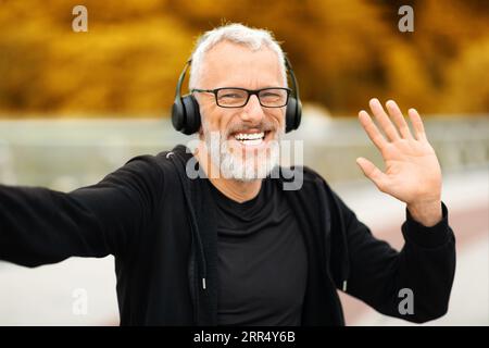 Célèbre blogueur fitness homme senior prenant selfie tout en faisant du jogging Banque D'Images