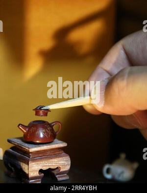 201216 -- JINAN, 16 décembre 2020 -- Wang Tianming présente sa sculpture miniature à Jinan, dans la province du Shandong de l est de la Chine, le 11 décembre 2020. Le micro-sculpteur Wang Tianming, 71 ans, est un maître provincial des arts et métiers connu pour ses sculptures miniatures. Wang peut non seulement sculpter des figures microscopiques sur du jade, des bouilloires à thé et des grains de riz, mais aussi sur une seule mèche de cheveux humains. L'artiste a méticuleusement confectionné des figures si détaillées depuis 35 ans. La micro-sculpture, aux yeux de Wang, est un savoir-faire artisanal du sentiment. Pourtant, le sentiment ne peut être acquis que le long de la pratique jour après jour. AS Banque D'Images