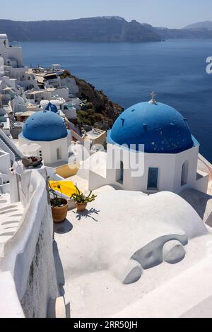 Bâtiments blanchis à la chaux sur le bord de la falaise de la caldeira dans le village d'Oia, Santorin, Grèce Banque D'Images