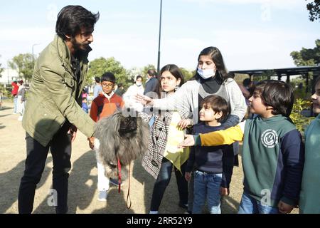 201220 -- RAWALPINDI, le 20 décembre 2020 -- des enfants essaient de toucher un chien lors de l'exposition canine toutes races à Rawalpindi, dans la province pakistanaise du Punjab, le 20 décembre 2020. Le All Breed Dog Show a eu lieu dimanche et a attiré de nombreux concurrents pour exposer leurs chiens. PAKISTAN-RAWALPINDI-CHIEN SPECTACLE AhmadxKamal PUBLICATIONxNOTxINxCHN Banque D'Images