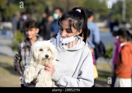 201220 -- RAWALPINDI, 20 décembre 2020 -- Une fille tient son chien lors de l'exposition canine toutes races à Rawalpindi, dans la province pakistanaise du Punjab, le 20 décembre 2020. Le All Breed Dog Show a eu lieu dimanche et a attiré de nombreux concurrents pour exposer leurs chiens. PAKISTAN-RAWALPINDI-CHIEN SPECTACLE AhmadxKamal PUBLICATIONxNOTxINxCHN Banque D'Images