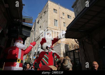 201223 -- PÉKIN, 23 décembre 2020 -- Un palestinien déguisé en gestes du Père Noël alors qu'il monte à dos de chameau dans la vieille ville de Jérusalem le 22 décembre 2020. Photo de /Xinhua XINHUA PHOTOS DU JOUR MuammarxAwad PUBLICATIONxNOTxINxCHN Banque D'Images