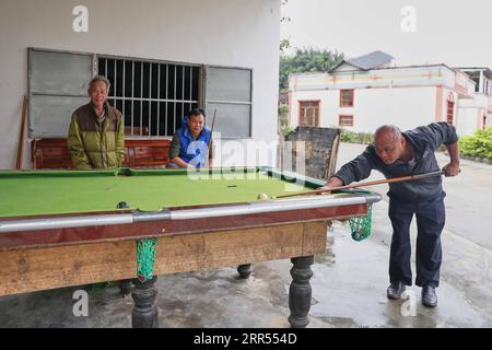 201222 -- HAIKOU, le 22 décembre 2020 -- des villageois jouent au billard dans le village de Baorui, comté de Qiongzhong, province de Hainan dans le sud de la Chine, le 17 décembre 2020. Les visiteurs sont susceptibles d'être impressionnés par les résidences flambant neuves et les routes pavées lisses lorsqu'ils viennent au village de Baorui dans la province de Hainan. Mais une telle scène est à peine imaginable en 2017 lorsque les gens du groupe ethnique Li habitant ici étaient pour la plupart embourbés dans la pauvreté et vivaient dans des maisons délabrées. À l'époque, le village n'avait que des sentiers boueux avec de nombreux endroits inaccessibles même à la circulation des motos. Pour un village qui cultive des hévéas comme seule source Banque D'Images