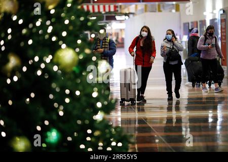 201224 -- ARLINGTON, le 24 décembre 2020 -- des voyageurs de vacances portant des masques faciaux sont vus à l'aéroport national Ronald Reagan Washington à Arlington, Virginie, États-Unis, le 23 décembre 2020. Dans son dernier avis, le CDC des Centers for Disease Control and Prevention des États-Unis a exhorté le public à éviter de voyager et à rester à la maison pendant les vacances de Noël pour freiner la propagation du virus COVID-19. La recommandation est venue alors que le pays continue de voir augmenter les cas de COVID-19, les décès et les hospitalisations. Photo par /Xinhua U.S.-ARLINGTON-AIRPORT-COVID-19-VOYAGEURS DE VACANCES TingxShen PUBLICATIONx Banque D'Images