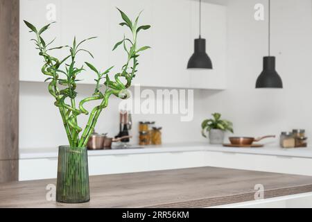 Vase avec tiges de bambou sur la table dans la cuisine Banque D'Images