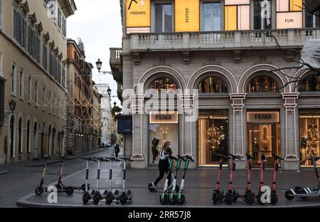 201225 -- ROME, le 25 décembre 2020 -- Une femme portant un masque facial conduit un scooter électrique devant un magasin fermé à Rome, Italie, le 24 décembre 2020. En Italie, les réglementations en vigueur jusqu'à Noël et le jour de l'an interdisent les déplacements non essentiels au-delà de 30 km de chez vous ou entre les régions. Les restaurants et les bars sont priés de fermer avant 6 heures, avec un couvre-feu national qui entrera en vigueur dans quatre heures. ITALIE-ROME-NOËL-COVID-19-RESTRICTIONS ChengxTingting PUBLICATIONxNOTxINxCHN Banque D'Images