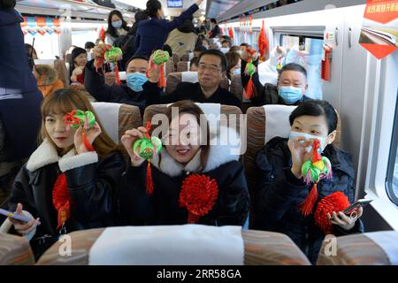 201226 -- YINCHUAN, 26 décembre 2020 -- des passagers montrent des cadeaux de membres d'équipage de train à bord du train à grande vitesse D4385 reliant Yinchuan à Xi an le 26 décembre 2020. Un nouveau chemin de fer à grande vitesse reliant Yinchuan, capitale de la région autonome hui de Ningxia, avec Xi an, capitale de la province du Shaanxi, toutes deux situées dans l'ouest de la Chine, a commencé à fonctionner à partir de samedi. Le chemin de fer de 610 km est construit avec un investissement de 80,5 milliards de yuans environ 12,33 milliards de dollars américains, et la vitesse du train est fixée à 250 km par heure. CHINA-NINGXIA-YINCHUAN-XI UNE EXPLOITATION FERROVIAIRE CN TANGXRUFENG PUBLICATIONXNOTXINXCHN Banque D'Images