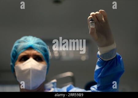 201228 -- PÉKIN, le 28 décembre 2020 -- Un travailleur médical montre un vaccin contre le COVID-19 dans un hôpital de Bucarest, Roumanie, le 27 décembre 2020. La Roumanie a commencé sa campagne de vaccination contre le coronavirus dimanche, et le premier à être vacciné est un travailleur médical qui, en février, a pris en charge le premier patient confirmé dans le pays. Photo de /Xinhua XINHUA PHOTOS DU JOUR CristianxCristel PUBLICATIONxNOTxINxCHN Banque D'Images