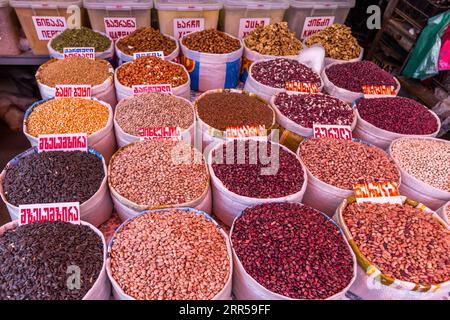 Grande sélection de haricots au marché Dezerter à Tbilissi. Dezerter Bazaar est le plus grand marché alimentaire de Tbilissi. Des plans circulent depuis début 2024 pour que le bâtiment principal fasse place à un centre commercial et que des centaines de commerçants perdent leurs stands autour de l’ancien bâtiment. Haricots dans un marché à Tbilissi, Géorgie Banque D'Images