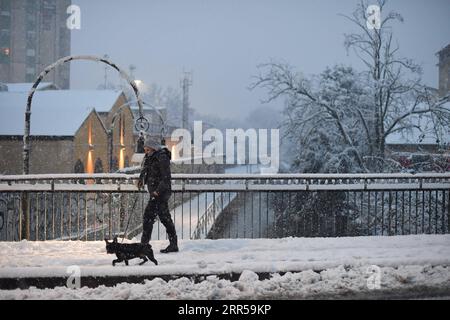 201228 -- MILAN ITALIE, 28 décembre 2020 -- Une femme promène un chien dans la neige à Milan, Italie, le 28 décembre 2020. Une chute de neige a frappé Milan lundi. Photo de /Xinhua ITALY-MILAN-SNOWFALL DanielexMascolo PUBLICATIONxNOTxINxCHN Banque D'Images
