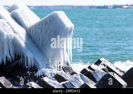 Blocs de béton couverts de glace comme brise-vagues sur la plage japonaise en hiver. Île de Hokkaido, Japon Banque D'Images