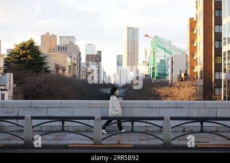 201231 -- TOKYO, le 31 décembre 2020 -- Une femme portant un masque facial traverse un pont à Tokyo, Japon, le 31 décembre 2020. Le nombre de nouveaux cas quotidiens de COVID-19 à Tokyo a dépassé la barre des 1 000 pour la première fois depuis l’apparition de la pandémie, a déclaré jeudi le gouverneur Yuriko Koike, avertissant que la troisième vague qui frappe la capitale est d’une taille sans précédent. JAPON-TOKYO-COVID-19-CAS DuxXiaoyi PUBLICATIONxNOTxINxCHN Banque D'Images