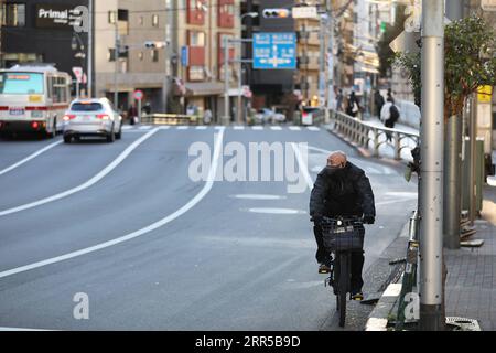 201231 -- TOKYO, 31 décembre 2020 -- Un homme portant un masque facial monte à vélo sur une route à Tokyo, Japon, 31 décembre 2020. Le nombre de nouveaux cas quotidiens de COVID-19 à Tokyo a dépassé la barre des 1 000 pour la première fois depuis l’apparition de la pandémie, a déclaré jeudi le gouverneur Yuriko Koike, avertissant que la troisième vague qui frappe la capitale est d’une taille sans précédent. JAPON-TOKYO-COVID-19-CAS DuxXiaoyi PUBLICATIONxNOTxINxCHN Banque D'Images