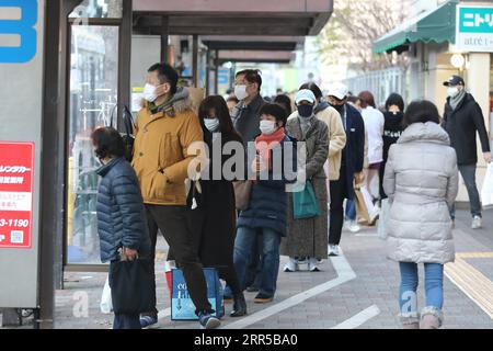 201231 -- TOKYO, 31 décembre 2020 -- des personnes portant un masque facial attendent un bus à une gare routière de Tokyo, Japon, 31 décembre 2020. Le nombre de nouveaux cas quotidiens de COVID-19 à Tokyo a dépassé la barre des 1 000 pour la première fois depuis l’apparition de la pandémie, a déclaré jeudi le gouverneur Yuriko Koike, avertissant que la troisième vague qui frappe la capitale est d’une taille sans précédent. JAPON-TOKYO-COVID-19-CAS DuxXiaoyi PUBLICATIONxNOTxINxCHN Banque D'Images