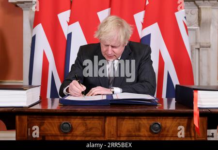 201231 -- LONDRES, le 31 décembre 2020 -- le Premier ministre britannique Boris Johnson signe l'accord commercial post-Brexit au 10 Downing Street, à Londres, en Grande-Bretagne, le 30 décembre 2020. Les législateurs britanniques ont approuvé mercredi l’accord commercial post-Brexit entre la Grande-Bretagne et l’Union européenne UE à une large majorité, ouvrant la voie à un Brexit ordonné lorsque la période de transition se terminera jeudi. /No 10 Downing Street/document via Xinhua GRANDE-BRETAGNE-LONDRES-PARLEMENT-ACCORD POST-BREXIT AndrewxParsons PUBLICATIONxNOTxINxCHN Banque D'Images