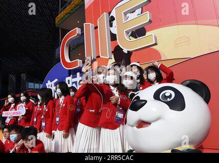 210101 -- BEIJING, le 1 janvier 2021 -- des volontaires posent pour une photo de groupe devant les décorations lors de la troisième China International Import Expo CIIE à Shanghai, dans l'est de la Chine, le 10 novembre 2020. Xinhua Headlines : Comment la Chine a surmonté les essais pour un 2021 haussier ZhaoxDingzhe PUBLICATIONxNOTxINxCHN Banque D'Images