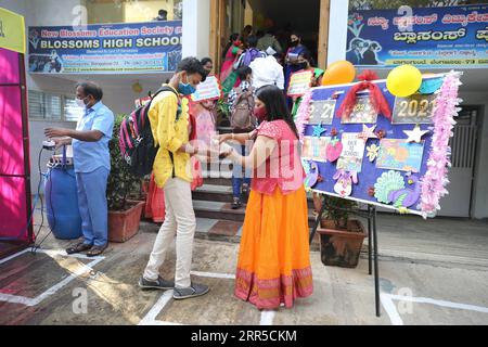210101 -- BANGALORE, le 1 janvier 2021 -- Un enseignant offre un désinfectant pour les mains à un élève d'une école de Bangalore, en Inde, le 1 janvier 2021. L’État du Karnataka, dans le sud du pays, a ouvert vendredi des écoles pour les élèves de 10e et 12e année, après un écart de plus de neuf mois. Str/ INDE-BANGALORE-COVID-19-RÉOUVERTURE DE L'ÉCOLE Xinhua PUBLICATIONxNOTxINxCHN Banque D'Images