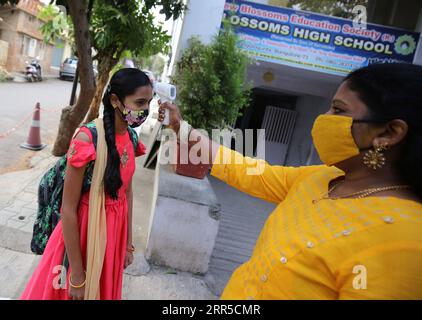 210101 -- BANGALORE, le 1 janvier 2021 -- Un enseignant vérifie la température corporelle d'un élève dans une école de Bangalore, en Inde, le 1 janvier 2021. L’État du Karnataka, dans le sud du pays, a ouvert vendredi des écoles pour les élèves de 10e et 12e année, après un écart de plus de neuf mois. Str/ INDE-BANGALORE-COVID-19-RÉOUVERTURE DE L'ÉCOLE Xinhua PUBLICATIONxNOTxINxCHN Banque D'Images