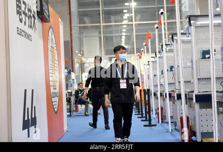 210105 -- CHONGQING, le 5 janvier 2021 -- Liang Pan travaille comme assistant de l'arbitre en électronique au premier concours national de compétences professionnelles à Guangzhou, dans la province du Guangdong, dans le sud de la Chine, le 10 décembre 2020. Liang Pan, qui a échoué à l'examen d'entrée au lycée, est maintenant professeur au Collège de technicien de transport ferroviaire de Chongqing. D'un élève de l'école secondaire professionnelle, un profane en électronique à un expert et un champion du monde, il a fallu 6 ans à Liang Pan pour réaliser le rêve. Les expériences de travail à un très jeune âge ont permis à Liang Pan de réaliser l'importance de la maîtrise Banque D'Images