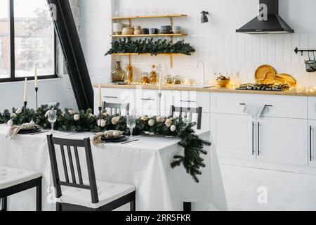 Décor de Noël sur la cuisine avec guirlande. Intérieur festif. Table de Noël sur lumières floues style scandinave Banque D'Images