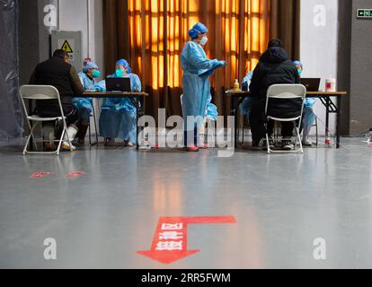 210106 -- BEIJING, le 6 janvier 2021 -- des membres du personnel confirment et enregistrent les lettres de consentement éclairé signées par des personnes qui sont sur le point de recevoir des vaccins contre la COVID-19 sur un site d'inoculation dans le district de Chaoyang, Beijing, capitale de la Chine, le 5 janvier 2021. Avec plus de 70 de ses collègues dans le secteur de la transformation des aliments, M. Wu dont le prénom est omis pour la protection de la vie privée, 40, est monté à bord d'une navette qui les amènerait à un site de vaccination vers 1 heures mardi. Wu, qui travaille pour une entreprise impliquée dans la pâtisserie, la boulangerie et le transport de la chaîne du froid, a déclaré que tous ses collègues excisez Banque D'Images