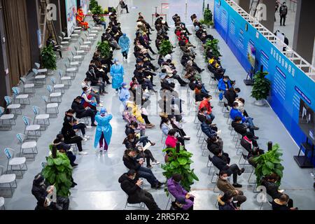 210106 -- BEIJING, le 6 janvier 2021 -- des travailleurs médicaux effectuent une inspection de patrouille à travers la zone d'observation pour les personnes qui viennent de recevoir des vaccins contre le COVID-19 sur un site d'inoculation dans le district de Chaoyang, Pékin, capitale de la Chine, le 5 janvier 2021. Avec plus de 70 de ses collègues dans le secteur de la transformation des aliments, M. Wu dont le prénom est omis pour la protection de la vie privée, 40, est monté à bord d'une navette qui les amènerait à un site de vaccination vers 1 heures mardi. Wu, qui travaille pour une entreprise impliquée dans la pâtisserie, la boulangerie et le transport de la chaîne du froid, a déclaré tous ses collègues sauf TH Banque D'Images