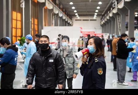 210106 -- BEIJING, le 6 janvier 2021 -- un membre du personnel guide les gens dans le couloir avant qu'ils reçoivent des vaccins contre la COVID-19 sur un site d'inoculation dans le district de Chaoyang, Beijing, capitale de la Chine, le 5 janvier 2021. Avec plus de 70 de ses collègues dans le secteur de la transformation des aliments, M. Wu dont le prénom est omis pour la protection de la vie privée, 40, est monté à bord d'une navette qui les amènerait à un site de vaccination vers 1 heures mardi. Wu, qui travaille pour une entreprise impliquée dans la pâtisserie, la boulangerie et le transport de la chaîne du froid, a déclaré tous ses collègues, sauf ceux qui ont une con physique inadaptée Banque D'Images