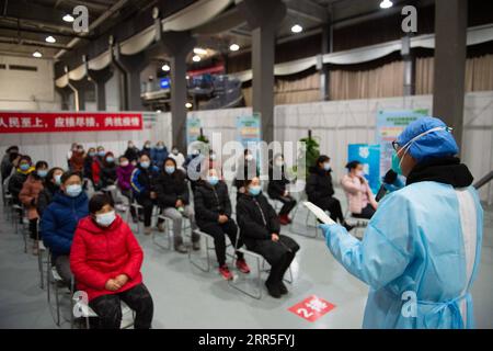 210106 -- BEIJING, 6 janvier 2021 -- les gens écoutent alors qu'un membre du personnel élabore des précautions avant de recevoir des vaccins contre le COVID-19 sur un site d'inoculation dans le district de Chaoyang, Pékin, capitale de la Chine, le 5 janvier 2021. Avec plus de 70 de ses collègues dans le secteur de la transformation des aliments, M. Wu dont le prénom est omis pour la protection de la vie privée, 40, est monté à bord d'une navette qui les amènerait à un site de vaccination vers 1 heures mardi. Wu, qui travaille pour une entreprise impliquée dans la pâtisserie, la boulangerie et le transport de la chaîne du froid, a déclaré tous ses collègues, sauf ceux qui ont une con physique inadaptée Banque D'Images