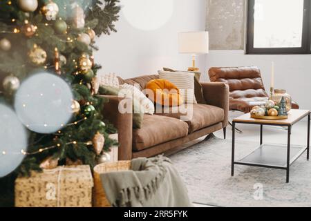 Fond de Noël de Livingroom intérieur. Boules et petits arbres de jouet de Noël sur plateau par canapé en couleur dorée et verte. Intérieur de la chambre du nouvel an Banque D'Images