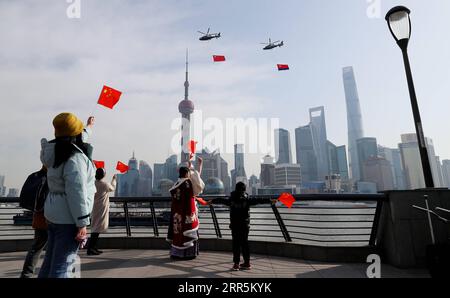 210110 -- SHANGHAI, le 10 janvier 2021 -- les gens agitent leurs drapeaux nationaux chinois comme des hélicoptères avec le drapeau national chinois et le drapeau de la police qui volent au-dessus de Shanghai de l'est de la Chine, le 10 janvier 2021. Des activités ont été organisées pour marquer la première Journée de la police du peuple chinois, qui tombe dimanche. CHINA-SHANGHAI-CHINESE PEOPLE S POLICE DAY CN FANGXZHE PUBLICATIONXNOTXINXCHN Banque D'Images