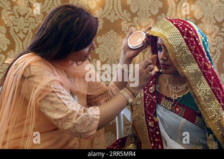 210110 -- KARACHI, 10 janvier 2021 -- Une maquilleuse maquille une mariée hindoue lors d'une cérémonie de mariage de masse pour quelque 48 couples dans la ville portuaire de Karachi, dans le sud du Pakistan, le 10 janvier 2021. Str/Xinhua PAKISTAN-KARACHI-MASS WEDDING Stringer PUBLICATIONxNOTxINxCHN Banque D'Images