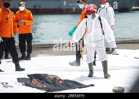 210111 -- JAKARTA, le 11 janvier 2021 -- un membre du personnel pulvérise du désinfectant sur un sac contenant des parties du corps des victimes, qui ont été récupérées dans les eaux où le vol Sriwijaya Air SJ-182 s'est écrasé, au port de Tanjung Priok à Jakarta, Indonésie, le 11 janvier 2021. L équipe de recherche et sauvetage de l Indonésie a élargi la zone d opération pour rechercher les débris et les victimes de l accident d avion de Sriwijaya Air avec plus de flottes le troisième jour d opérations, a déclaré lundi l Agence nationale indonésienne de recherche et sauvetage. Jusqu'à présent, les officiers ont trouvé l'épave de l'avion malheureux et des objets de parties du corps t Banque D'Images