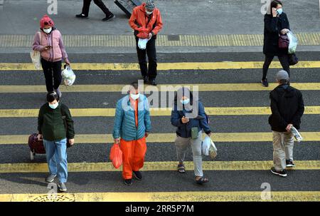 210112 -- HONG KONG, le 12 janvier 2021 -- des personnes portant des masques faciaux traversent la rue dans le sud de la Chine à Hong Kong, le 12 janvier 2021. Le Centre de protection de la santé de Hong Kong CHP a signalé mardi 60 cas confirmés supplémentaires de COVID-19, portant son total à 9 343. Les 60 nouveaux cas sont tous des infections locales, dont 13 d'origine inconnue. POUR ALLER AVEC Hong Kong rapporte 60 nouveaux cas de COVID-19, toutes les infections locales CHINE-HONG KONG-COVID-19-CAS CN LoxPingxFai PUBLICATIONxNOTxINxCHN Banque D'Images