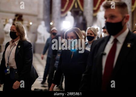210114 -- WASHINGTON, D.C., le 14 janvier 2021 -- Nancy Pelosi C, Présidente de la Chambre des représentants des États-Unis portant un masque de protection, marche dans les couloirs du Capitole à Washington, D.C., États-Unis, le 13 janvier 2021. POUR ALLER AVEC LES GROS TITRES XINHUA DE JAN. 14, 2021 photo de /Xinhua U.S.-WASHINGTON, D.C. TRUMP-IMPEACHMENT TingxShen PUBLICATIONxNOTxINxCHN Banque D'Images