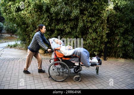 210126 -- HEFEI, 26 janvier 2021 -- Liu Ning emmène son petit ami Peng Yalou dehors pour profiter de l'air frais à Hefei, dans la province d'Anhui de l'est de la Chine, le 13 janvier 2021. Peng Yalou est dans le coma depuis plus de trois ans après un accident survenu en 2017. Sa petite amie Liu Ning ne l'a pas quitté et a choisi de rester et de prendre soin de lui. Pour prévenir l'atrophie musculaire due à des années d'inactivité, Liu le masse régulièrement des bras aux pieds et l'aide à s'entraîner à la rééducation. Sous les soins soignés d'elle, Peng récupère progressivement et prend conscience. Elle croit que des miracles arriveraient, et h Banque D'Images