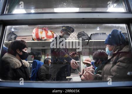 210128 -- PÉKIN, le 28 janvier 2021 -- un membre d'équipage vérifie les billets du train 3603 de Pékin à Chongqing, à Pékin, capitale de la Chine, le 28 janvier 2021. La ruée des voyages du Festival du printemps, connue comme la plus grande migration humaine annuelle au monde, dure 40 jours du 28 janvier au 8 mars de cette année. CHINE-SPRING FESTIVAL-TRAVEL RUSH CN ZHANGXCHENLIN PUBLICATIONXNOTXINXCHN Banque D'Images