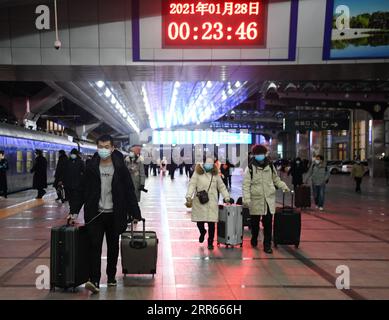 210128 -- BEIJING, le 28 janvier 2021 -- les passagers marchent pour monter à bord de leur train à la gare de Beijing, à Beijing, capitale de la Chine, le 28 janvier 2021. La ruée des voyages du Festival du printemps, connue comme la plus grande migration humaine annuelle au monde, dure 40 jours du 28 janvier au 8 mars de cette année. CHINE-SPRING FESTIVAL-TRAVEL RUSH CN ZHANGXCHENLIN PUBLICATIONXNOTXINXCHN Banque D'Images