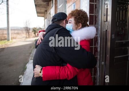 210128 -- WUHAN, le 28 janvier 2021 -- Gao Li embrasse sa mère après avoir reçu une désinfection dans le village de Shuikousi de la ville de Caijiazha, district de Hangpi de la ville de Wuhan, province du Hubei en Chine centrale, le 28 janvier 2021. Le premier jour de la ruée des voyages du Festival du Printemps en 2021, Gao Li, un travailleur migrant post-90 à Shanghai, a emballé ses bagages et a mis le pied sur le chemin du retour vers sa ville natale de Huangpi, Wuhan de Chine centrale pour le Festival du Printemps. Avant de s'enregistrer, il a fouillé pour le rapport de test d'acide nucléique négatif dans son sac. Rien ne pourrait être plus important que ce bagage. Il y a deux jours Banque D'Images