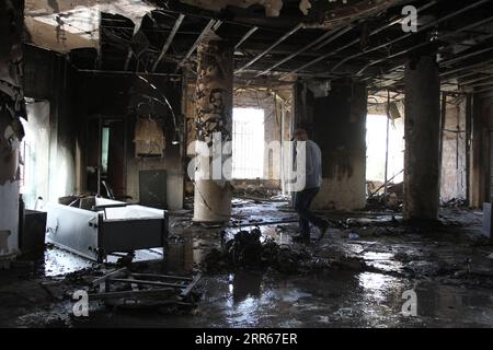 210129 -- TRIPOLI LIBAN, le 29 janvier 2021 -- Un homme est vu à l'intérieur d'un bâtiment endommagé par des manifestants à Tripoli, dans le nord du Liban, le 29 janvier 2021. Les hauts responsables libanais ont condamné vendredi les violentes manifestations qui ont eu lieu à Tripoli au cours des quatre derniers jours et qui ont fait des centaines de blessés en tuant un jeune homme, a rapporté l'Agence nationale de presse. Photo de /Xinhua LIBAN-TRIPOLI-AFFRONTEMENTS VIOLENTS-CONSÉQUENCES Khaled PUBLICATIONxNOTxINxCHN Banque D'Images