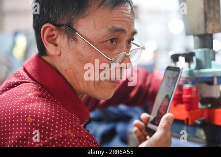 210202 -- FUZHOU, 2 février 2021 -- Zhang Liangguo a une conversation vidéo avec son fils aîné à Wellgreen Outdoor Co., Ltd. Dans le comté de Minhou, Fuzhou, province du Fujian au sud-est de la Chine, le 25 janvier 2021. Suite à la résurgence de cas sporadiques de COVID-19, de nombreux endroits à travers la Chine ont encouragé les résidents et les travailleurs migrants à rester présents pour célébrer la fête du printemps, pour réduire le flux de personnel et freiner la propagation du coronavirus pendant la période des fêtes. Dans le comté de Minhou de Fuzhou, province du Fujian, une usine de matériel extérieur a donné des kits de cadeau de nouvel an à plus de 90 travailleurs qui ont décidé n Banque D'Images