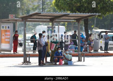 Myanmar, Rangun nach dem Militärputsch 210202 -- YANGON, 2 février 2021 -- des gens attendent un bus à un arrêt de bus à Yangon, Myanmar, 2 février 2021. La majorité des ministres régionaux et des chefs d'État ont été libérés mardi après la détention d'une journée par l'armée, a déclaré un haut responsable militaire à Xinhua. Aung San Suu Kyi, conseillère d'État du Myanmar, U Win Myint, président et d'autres hauts responsables de la Ligue nationale pour la démocratie au pouvoir, la LND, avaient été arrêtés par l'armée tôt lundi. Le Bureau du Président a déclaré l état d urgence pour un an et le pouvoir de l État a été transféré au Commandement Banque D'Images