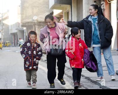 210203 -- LIANGSHAN, le 3 février 2021 -- Bamu Yubumu marche avec ses enfants vers un marché de rue dans le village de Taoyuan, comté de Yuexi, préfecture autonome de Liangshan Yi, province du Sichuan dans le sud-ouest de la Chine, le 22 janvier 2021. Une jeune mère s'est penchée ardemment vers l'avant pour équilibrer le poids d'un bagage surdimensionné sur son dos et d'un petit bébé dans son bras, alors qu'elle se battait ses pas en avant. C'est l'image qu'un journaliste de Xinhua a capturée près de la gare de Nanchang à Nanchang, dans la province de Jiangxi, dans l'est de la Chine, le 30 janvier 2010. La photo intitulée Baby, MOM Takes You Home a touché le cœur de millions de personnes quand elle l’a été Banque D'Images