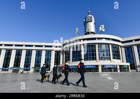 210203 -- TIANJIN, le 3 février 2021 -- des policiers et des chiens policiers patrouillent sur la place de la gare ferroviaire de Tianjin, dans le nord de la Chine, Tianjin, le 1 février 2021. Fen Di , un chien hybride allemand hollandais et également chien de garde de la succursale de Tianjin du bureau de sécurité publique des chemins de fer de Pékin, travaille et vit avec son entraîneur Zhao hui depuis trois ans. Il y a maintenant une douzaine de chiens comme Fen Di ici, qui agissent comme gardes dans la patrouille de routine et de bons partenaires dans l'entraînement. Au cours de la course de voyage de la fête du printemps de cette année, plus de patrouilles pour Fen Di et ses compagnons de chiens sont organisées au Tianjin Railway Banque D'Images