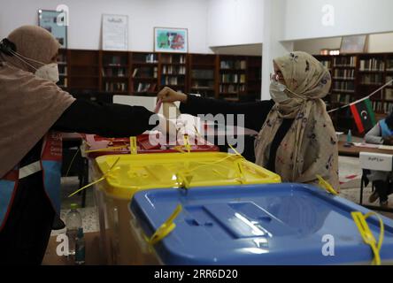 210206 -- TRIPOLI, le 6 février 2021 -- Une femme jette son bulletin de vote dans un bureau de vote à Tripoli, en Libye, le 6 février 2021. Le Comité central libyen pour les élections des conseils municipaux le CCMCE a annoncé samedi la clôture des élections municipales de la capitale Tripoli. Photo de /Xinhua LIBYE-TRIPOLI-ÉLECTIONS MUNICIPALES HamzaxTurkia PUBLICATIONxNOTxINxCHN Banque D'Images