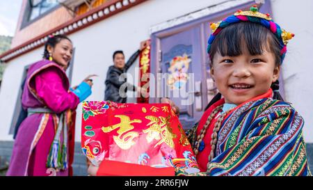 210212 -- LHASSA, 12 février 2021 -- Zhang Chunhuan et les membres de sa famille collent des couplets à la veille du nouvel an lunaire chinois à Medog, dans la région autonome du Tibet du sud-ouest de la Chine, le 11 février 2021. Le nouvel an tibétain a coïncidé avec la fête du printemps cette année. Medog, avec une altitude moyenne de 1 200 mètres, est situé dans le cours inférieur de la rivière Yarlung Zangbo. En raison de la mauvaise infrastructure de circulation dans le passé, Medog était autrefois connu comme une île isolée sur le plateau. Il y a huit ans, Zhang Chunhuan, un jeune homme de la province du Shanxi, est venu à Medog. À ce moment, le trafic en t Banque D'Images