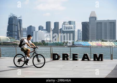 210216 -- BEIJING, le 16 février 2021 -- Un homme fait du vélo le long de la Marina Bay à Singapour le 15 février 2021. Le ministère du Commerce et de l'Industrie de Singapour MTI a déclaré lundi qu'il avait maintenu les prévisions de croissance du PIB pour 2021 à 4 à 6 pour cent, en tenant compte de l'évolution de l'environnement économique mondial et national. PHOTOS XINHUA DU JOUR ThenxChihxWey PUBLICATIONxNOTxINxCHN Banque D'Images