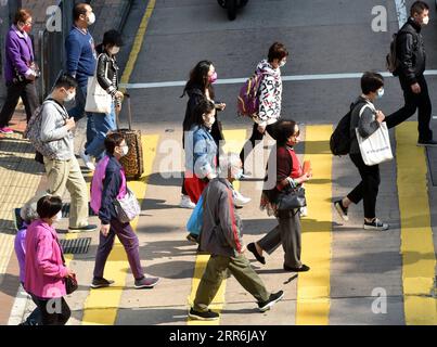 210218 -- HONG KONG, le 18 février 2021 -- des personnes portant un masque facial marchent dans une rue à Hong Kong, dans le sud de la Chine, le 18 février 2021. Le Centre de protection de la santé de Hong Kong CHP a signalé huit nouvelles infections au COVID-19 jeudi, portant le total à 10 820. CHINE-HONG KONG-COVID-19-CASESCN LoxPingxFai PUBLICATIONxNOTxINxCHN Banque D'Images