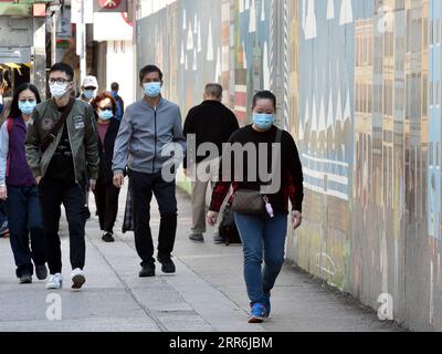 210218 -- HONG KONG, le 18 février 2021 -- des personnes portant un masque facial marchent dans une rue à Hong Kong, dans le sud de la Chine, le 18 février 2021. Le Centre de protection de la santé de Hong Kong CHP a signalé huit nouvelles infections au COVID-19 jeudi, portant le total à 10 820. CHINE-HONG KONG-COVID-19-CASESCN LoxPingxFai PUBLICATIONxNOTxINxCHN Banque D'Images